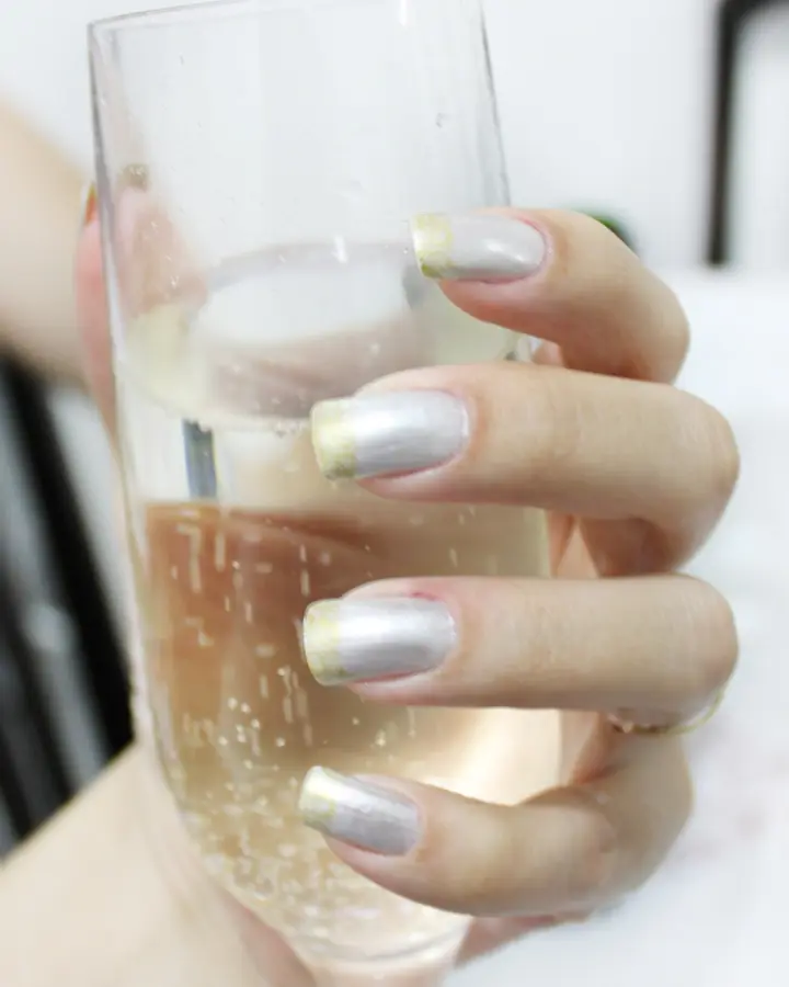 Silver metallic nails holding a glass