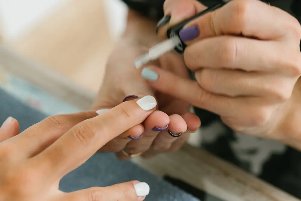 Manicurist painting a client's nails