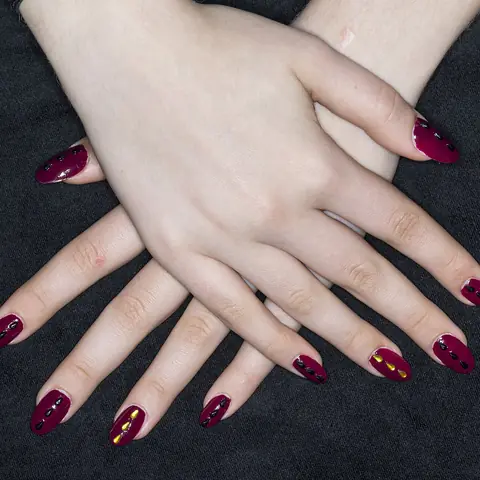 Almond shaped acrylic nails in deep burgundy